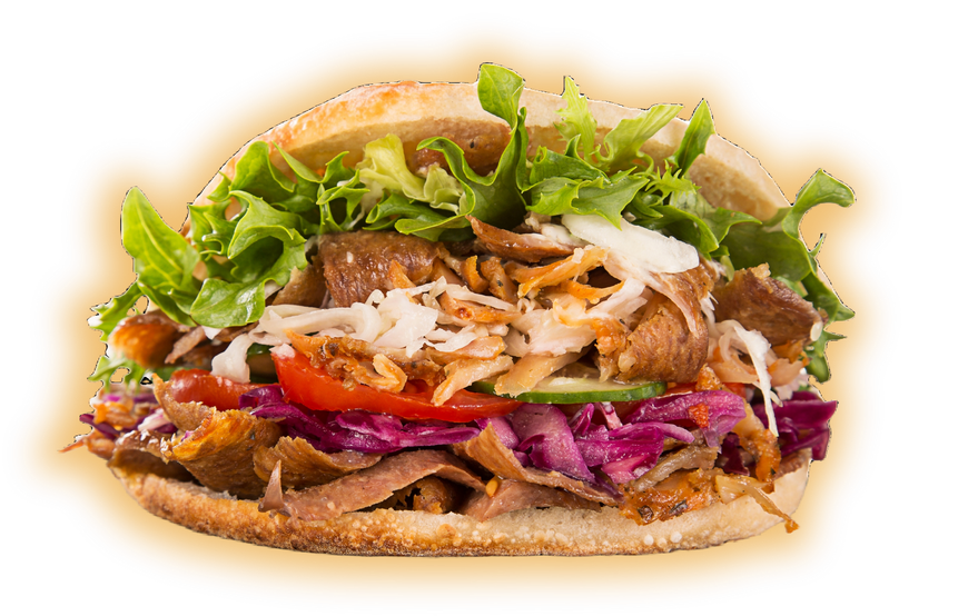 A close up of a kebab sandwich with lettuce , tomatoes , and cabbage on a white background.