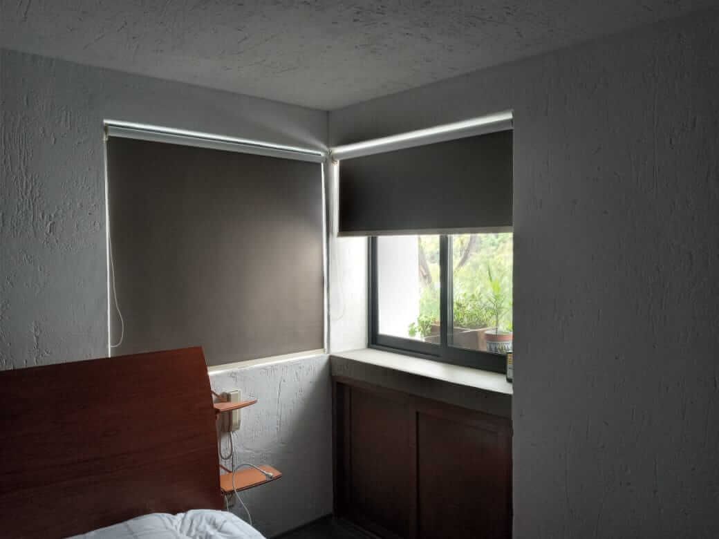 Un dormitorio con una cama y una ventana con persianas.