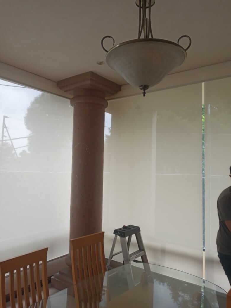 Un comedor con una mesa y sillas y una lámpara colgando del techo.