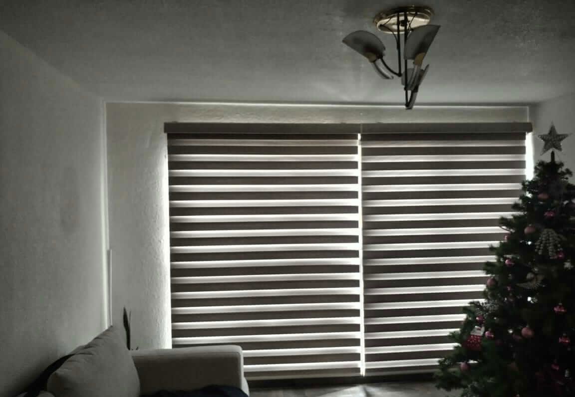 Una sala de estar con un sofá y un árbol de navidad.