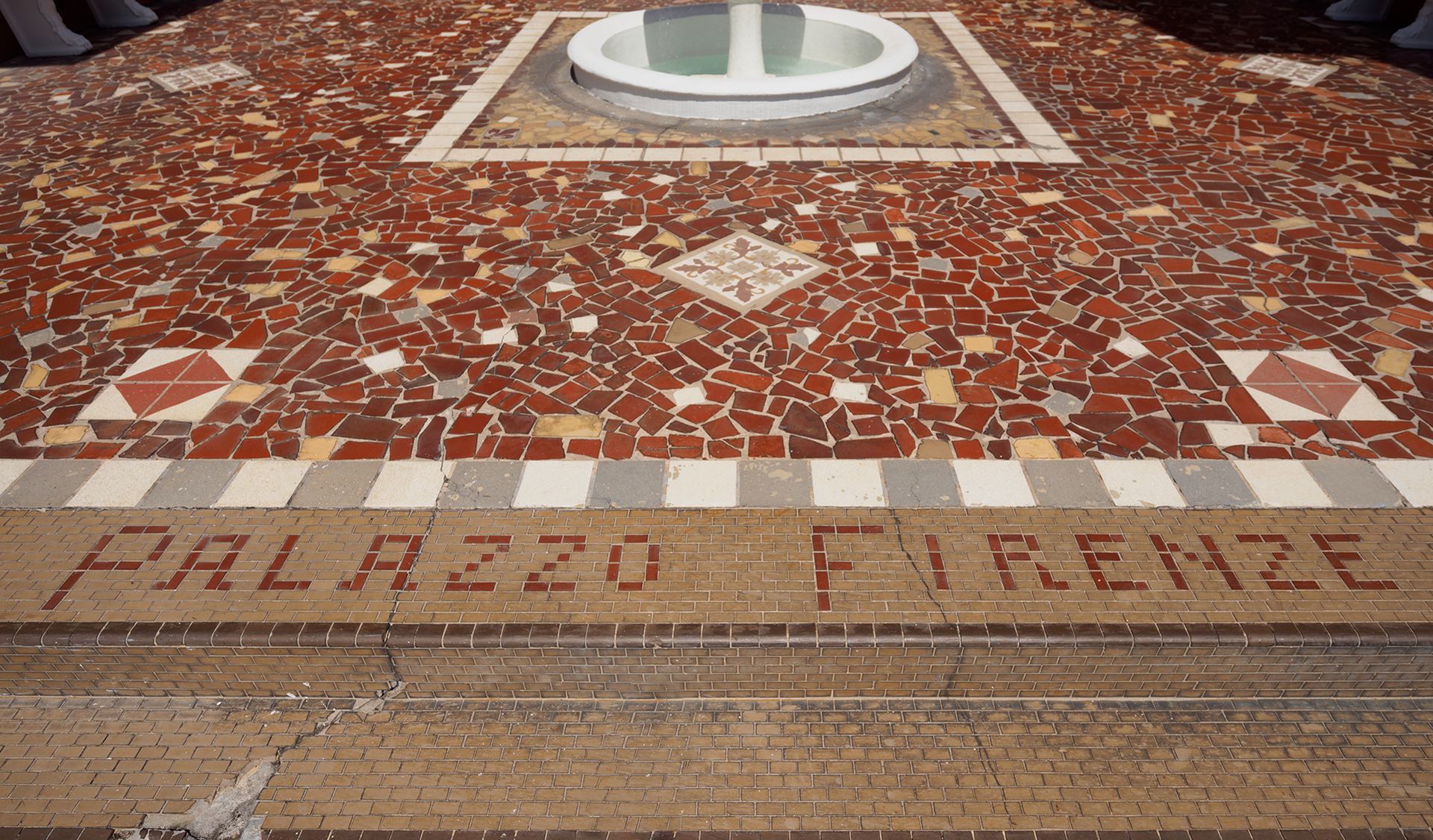 Photo of a building name, written in colored tiles on the ground
