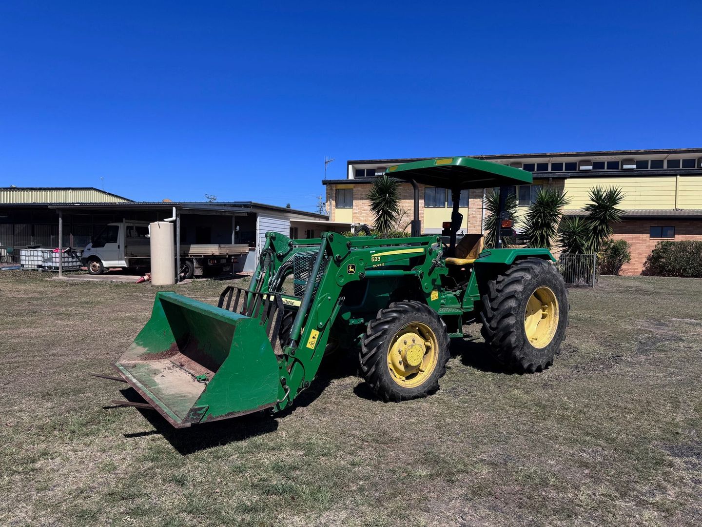 Green John Deere Tractor with A Front Loader Sits on Grass — Bundaberg Auction Centre in Gooburrum, QLD