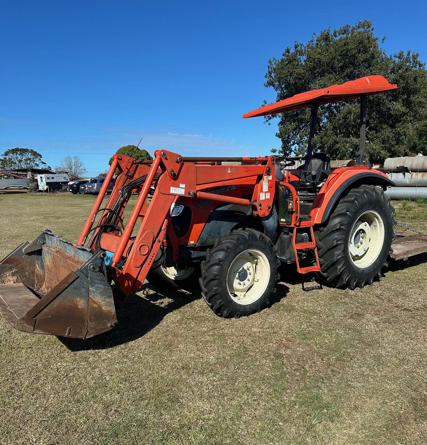 Orange Tractor with Front Loader and Sunshade on A Grassy Field — Bundaberg Auction Centre in Gooburrum, QLD