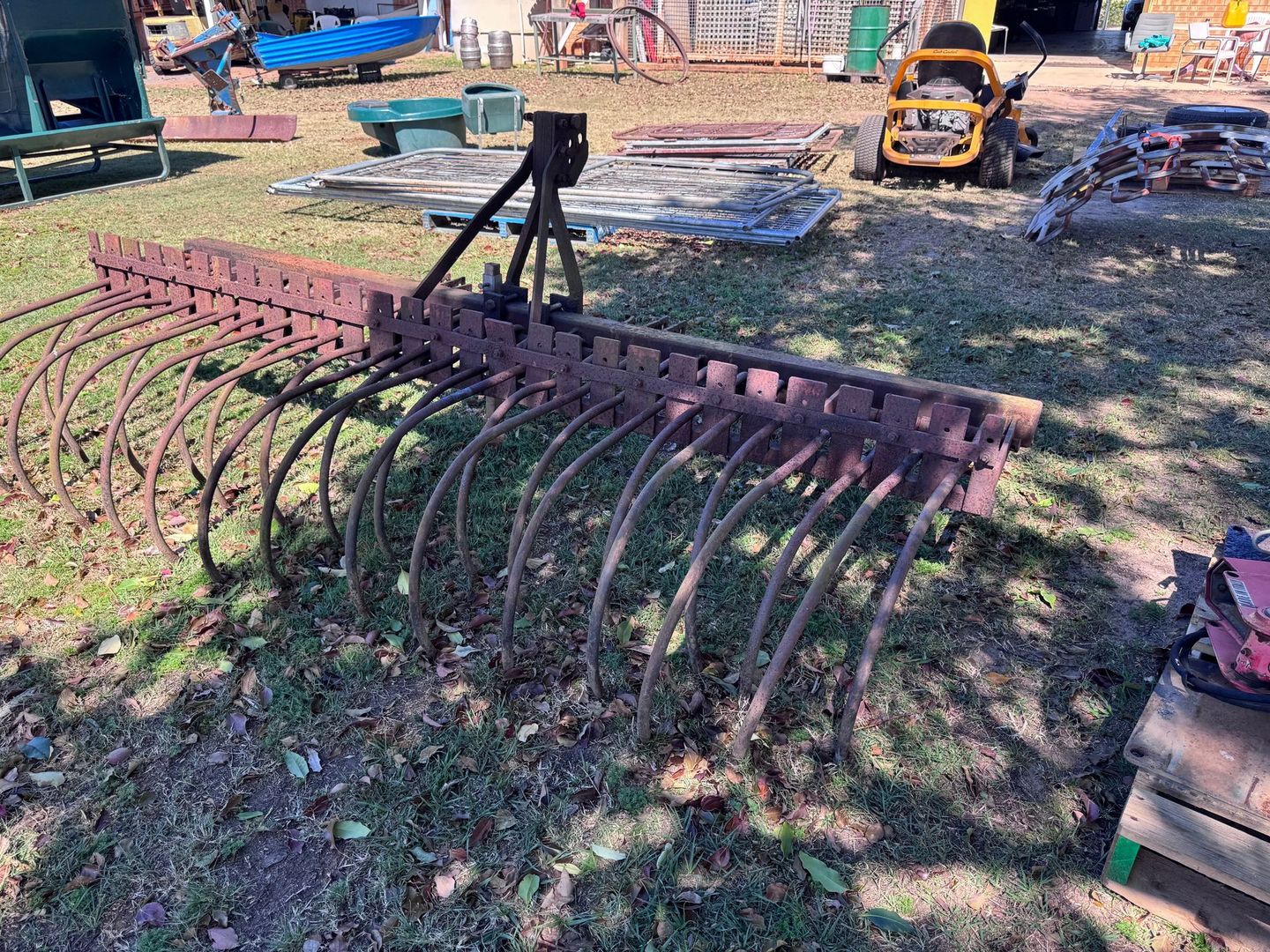 Antique Field Rake with Curved Metal Tines, on Grass — Bundaberg Auction Centre in Gooburrum, QLD