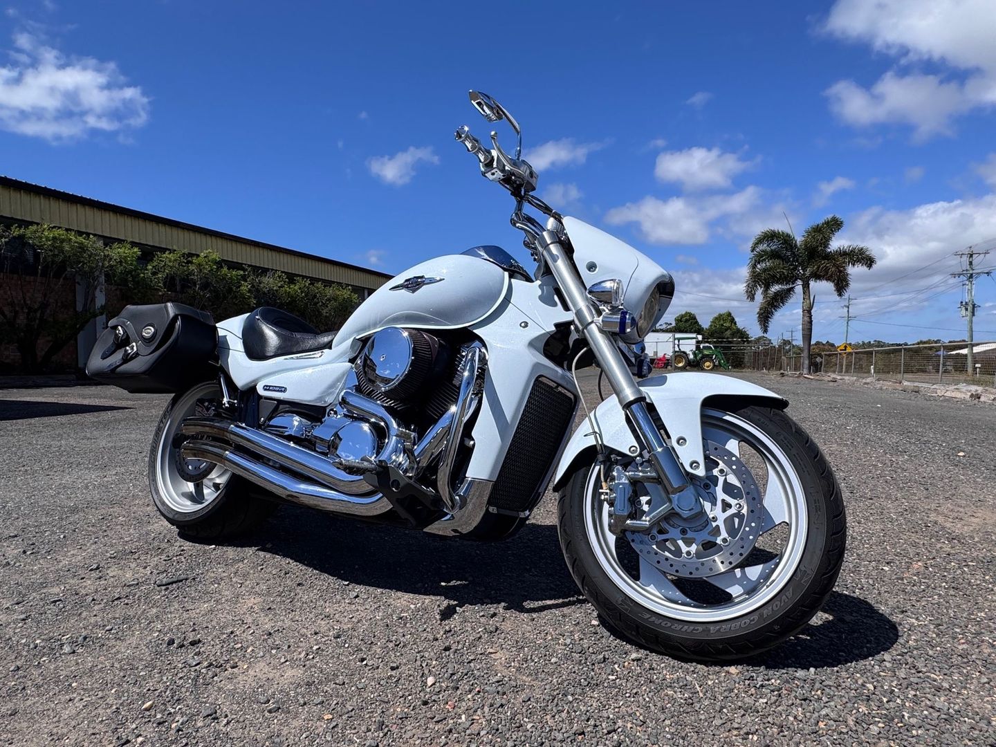 White Suzuki Motorcycle Parked on Asphalt Under a Clear Blue Sky — Bundaberg Auction Centre in Gooburrum, QLD