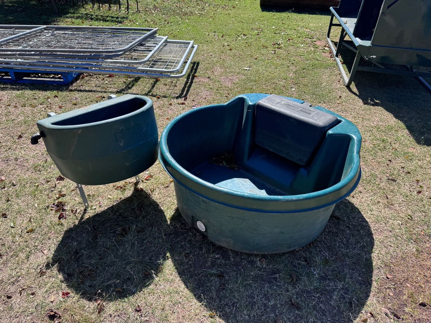 Two Green Livestock Water Troughs on Grass — Bundaberg Auction Centre in Gooburrum, QLD