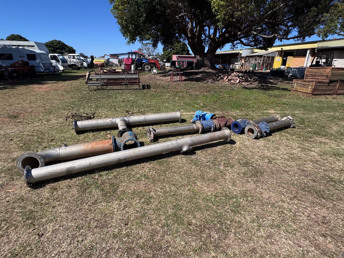 Pipes and Valves Lying on Grass at An Outdoor Market — Bundaberg Auction Centre in Gooburrum, QLD