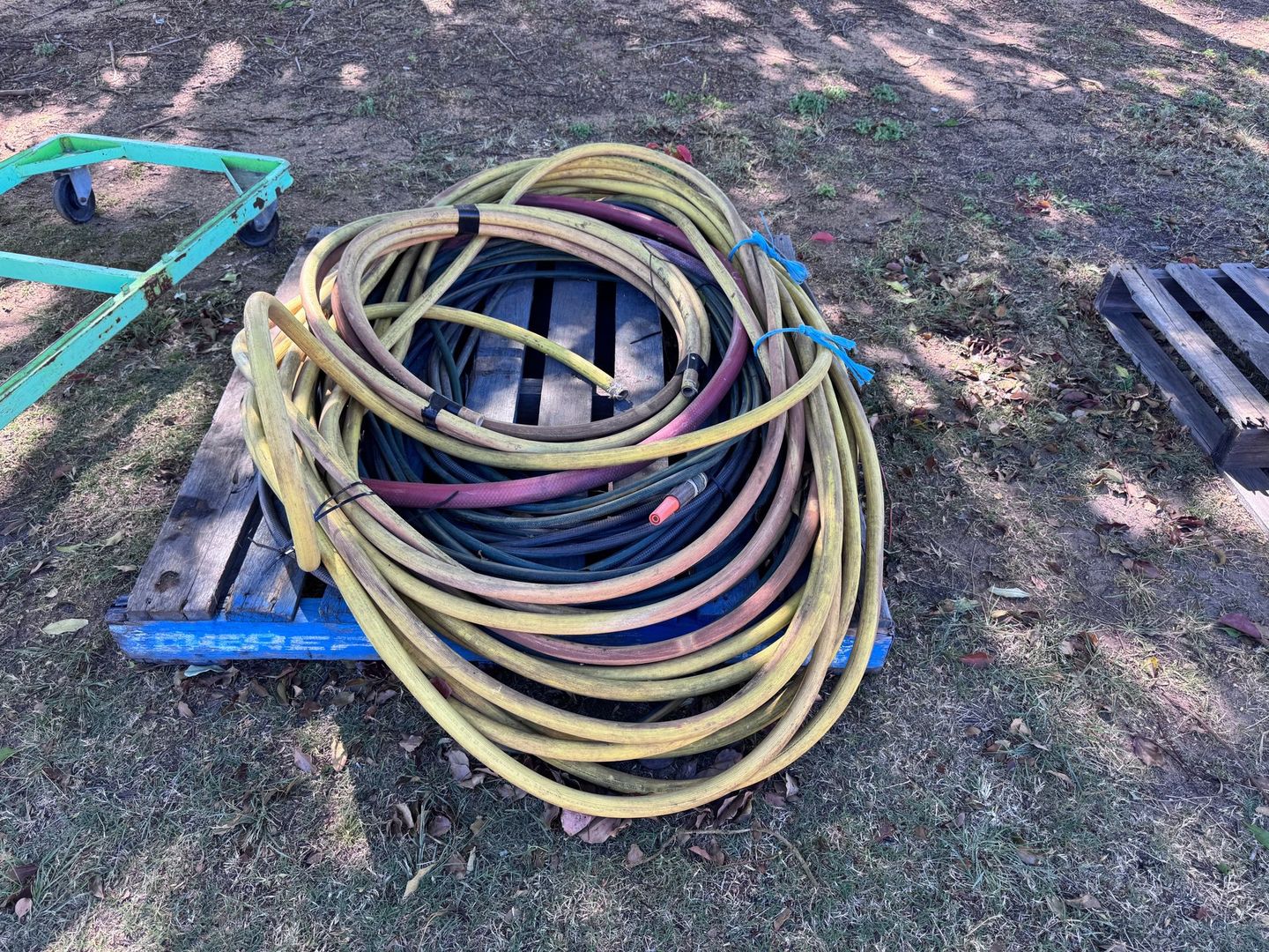 Coiled Yellow Hoses on A Blue Pallet Outdoor — Bundaberg Auction Centre in Gooburrum, QLD