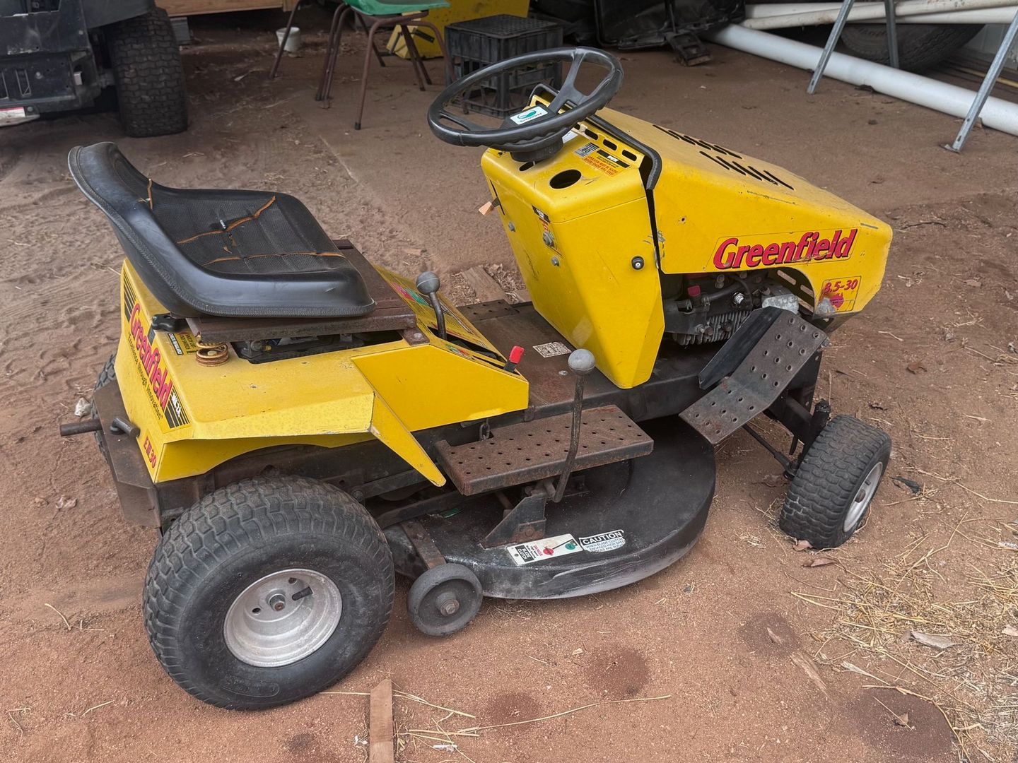 Yellow Greenfield Ride-On Mower on A Dirt Surface — Bundaberg Auction Centre in Gooburrum, QLD