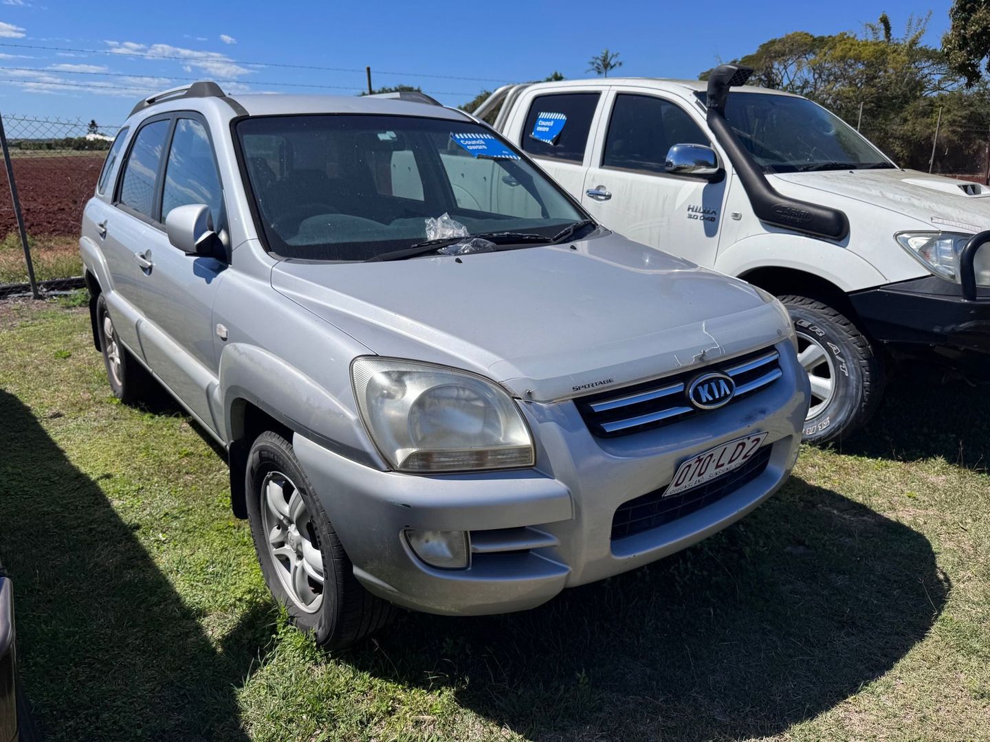 Silver Kia Sportage Suv Parked on Grass — Bundaberg Auction Centre in Gooburrum, QLD