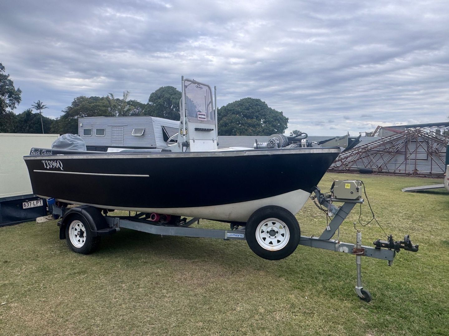 Black Boat on A Trailer in A Grassy Field Under a Cloudy Sky — Bundaberg Auction Centre in Gooburrum, QLD