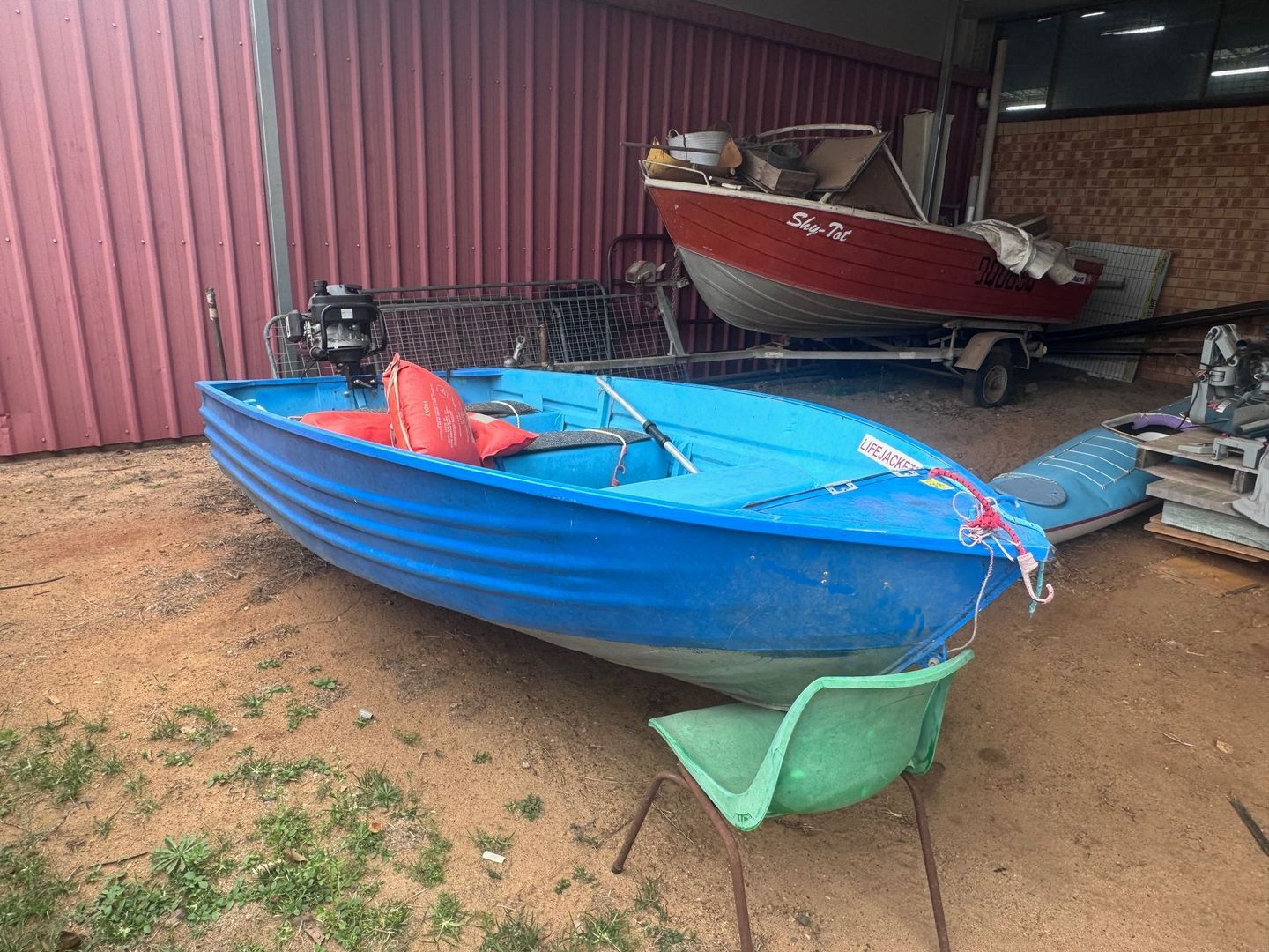 Blue Rowboat with Outboard Motor Sits on Ground — Bundaberg Auction Centre in Gooburrum, QLD