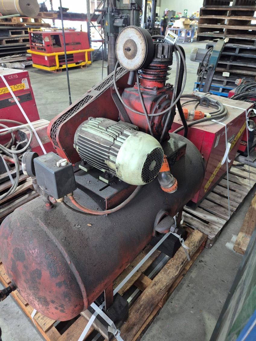 Red Industrial Air Compressor on A Wooden Pallet — Bundaberg Auction Centre in Gooburrum, QLD