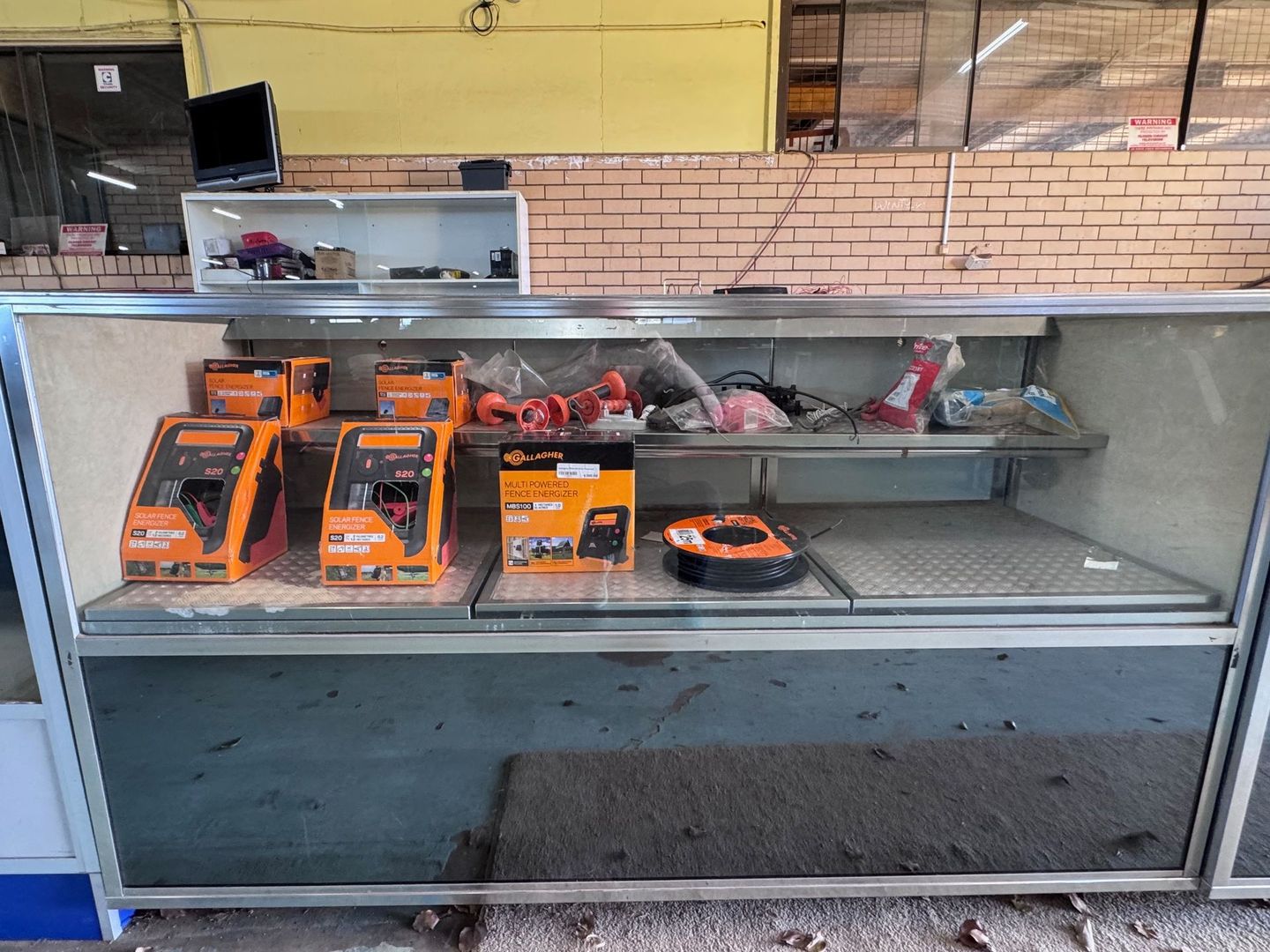 Display Case with Orange Boxed Tools and Other Items — Bundaberg Auction Centre in Gooburrum, QLD