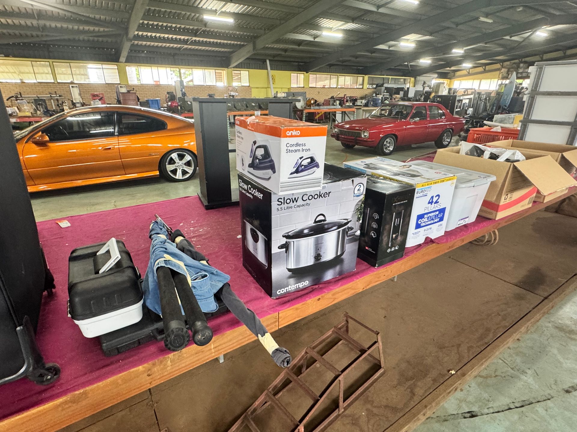 Indoor Warehouse Sale with Various Boxed Items on Display, Including a Slow Cooker — Bundaberg Auction Centre in Gooburrum, QLD
