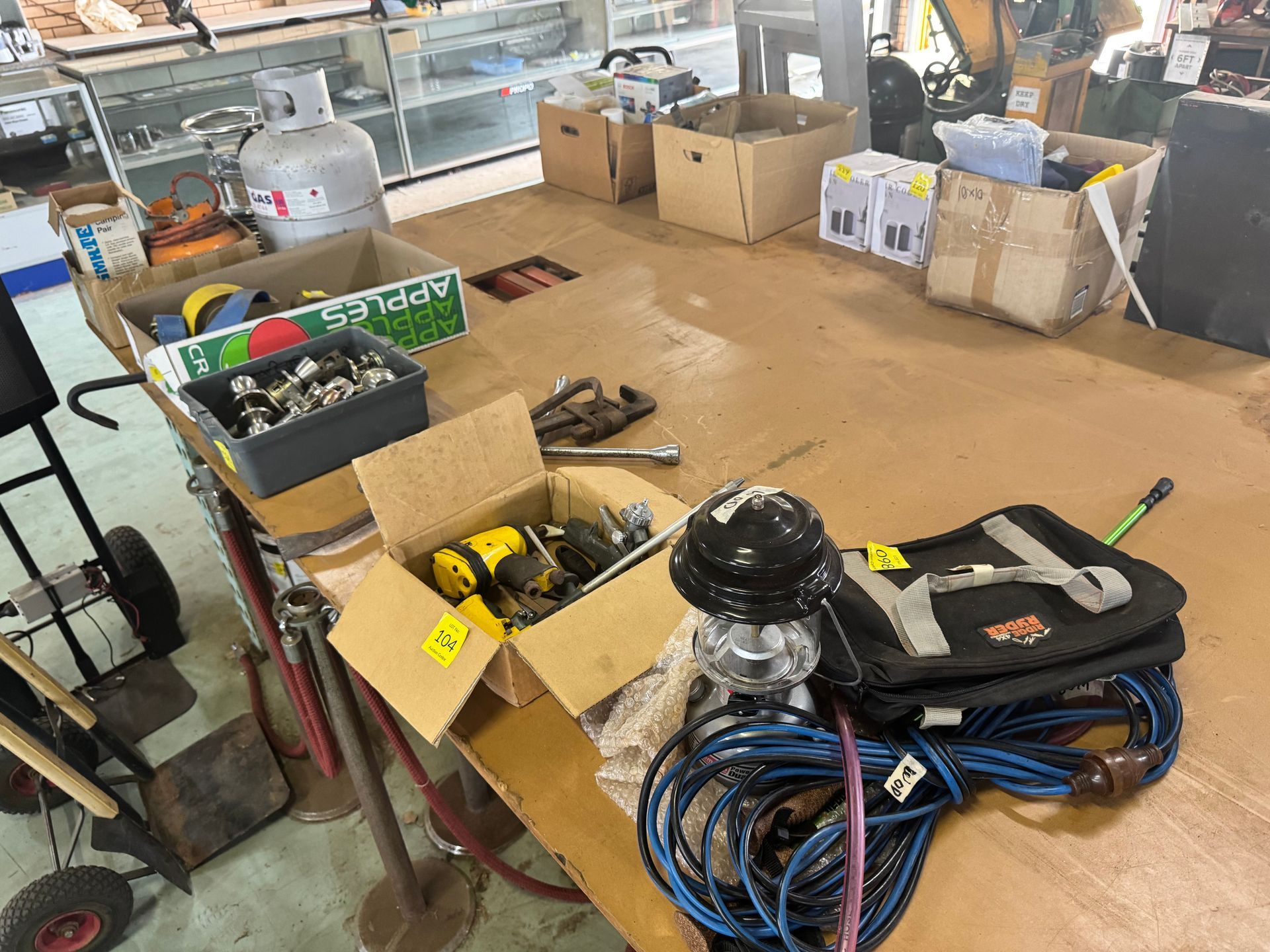 Tabletop Display with Tools, Boxes, and A Propane Tank in A Cluttered Workshop — Bundaberg Auction Centre in Gooburrum, QLD