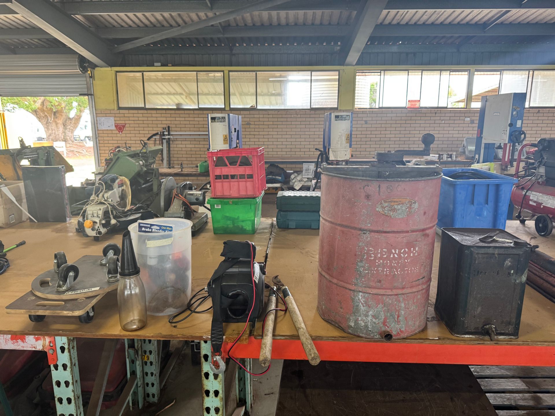 Workshop Scene with Workbench Displaying Tools, Red Barrel, and Various Containers — Bundaberg Auction Centre in Gooburrum, QLD