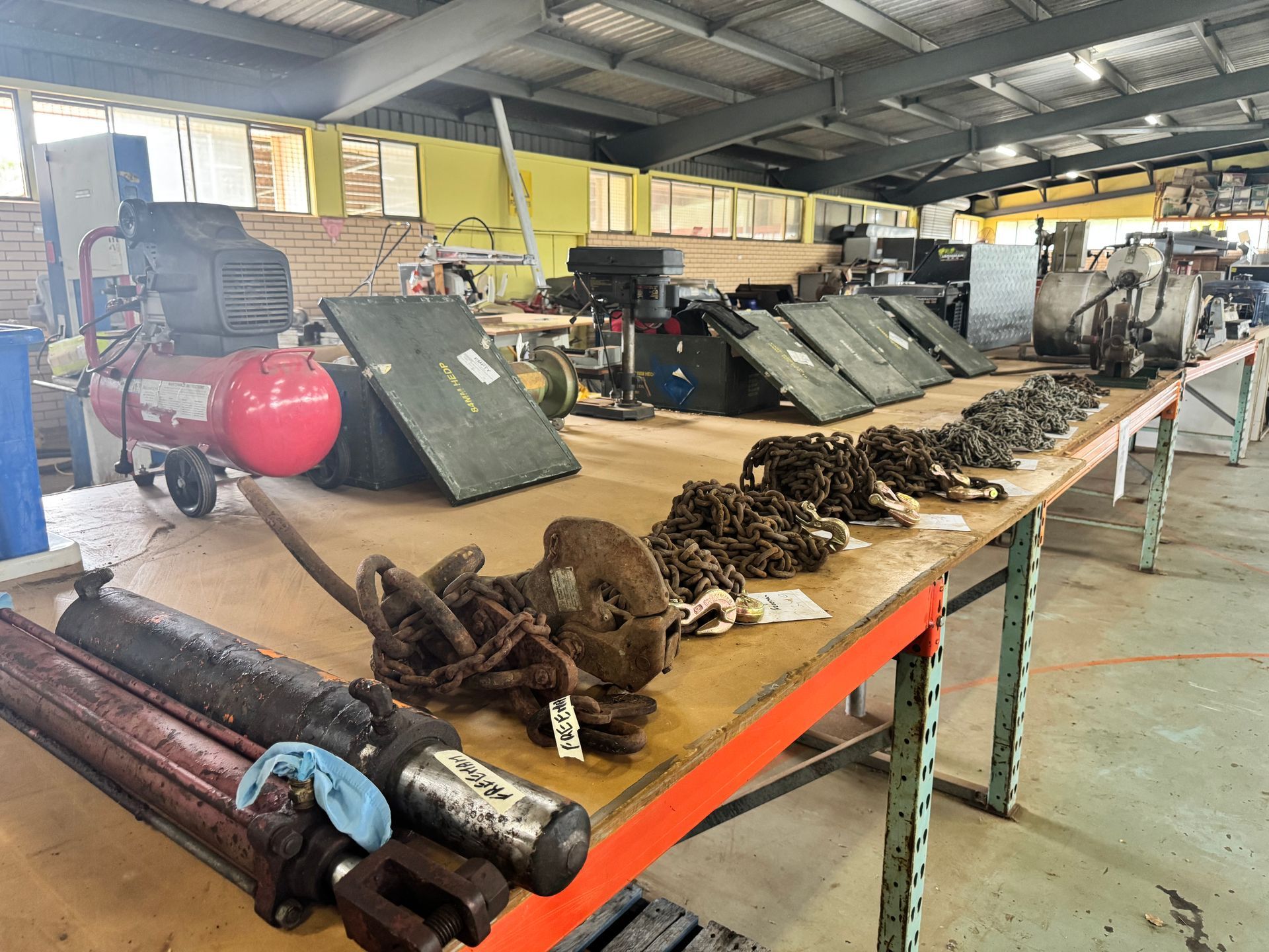 Workshop Interior with Tools, Chains, and Equipment on A Long Workbench; Air Compressor — Bundaberg Auction Centre in Gooburrum, QLD