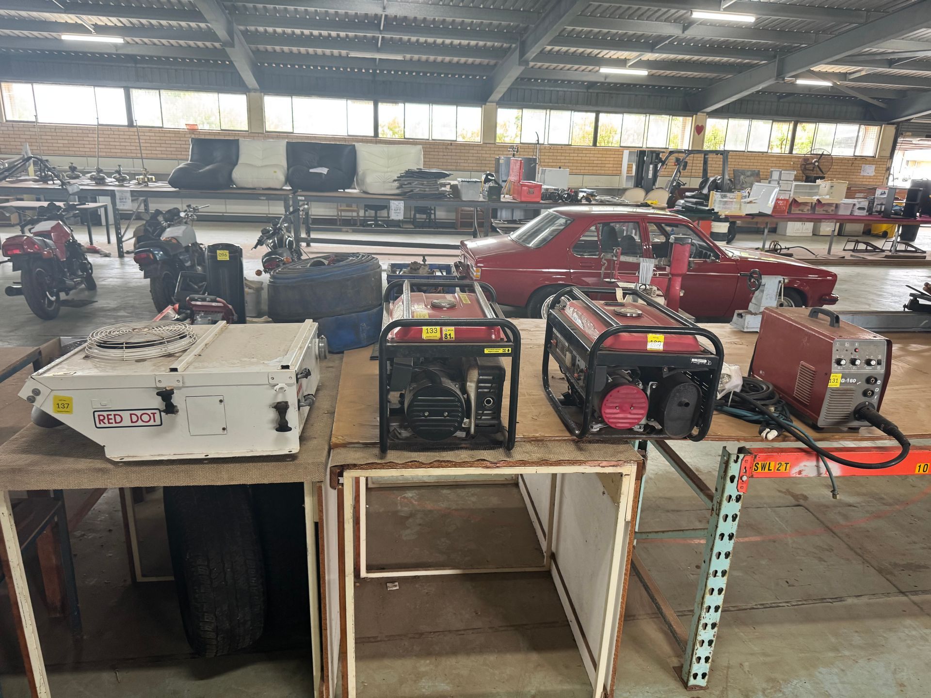 Generators, a Welder, and Auto Parts Displayed on Tables in A Large Workshop — Bundaberg Auction Centre in Gooburrum, QLD
