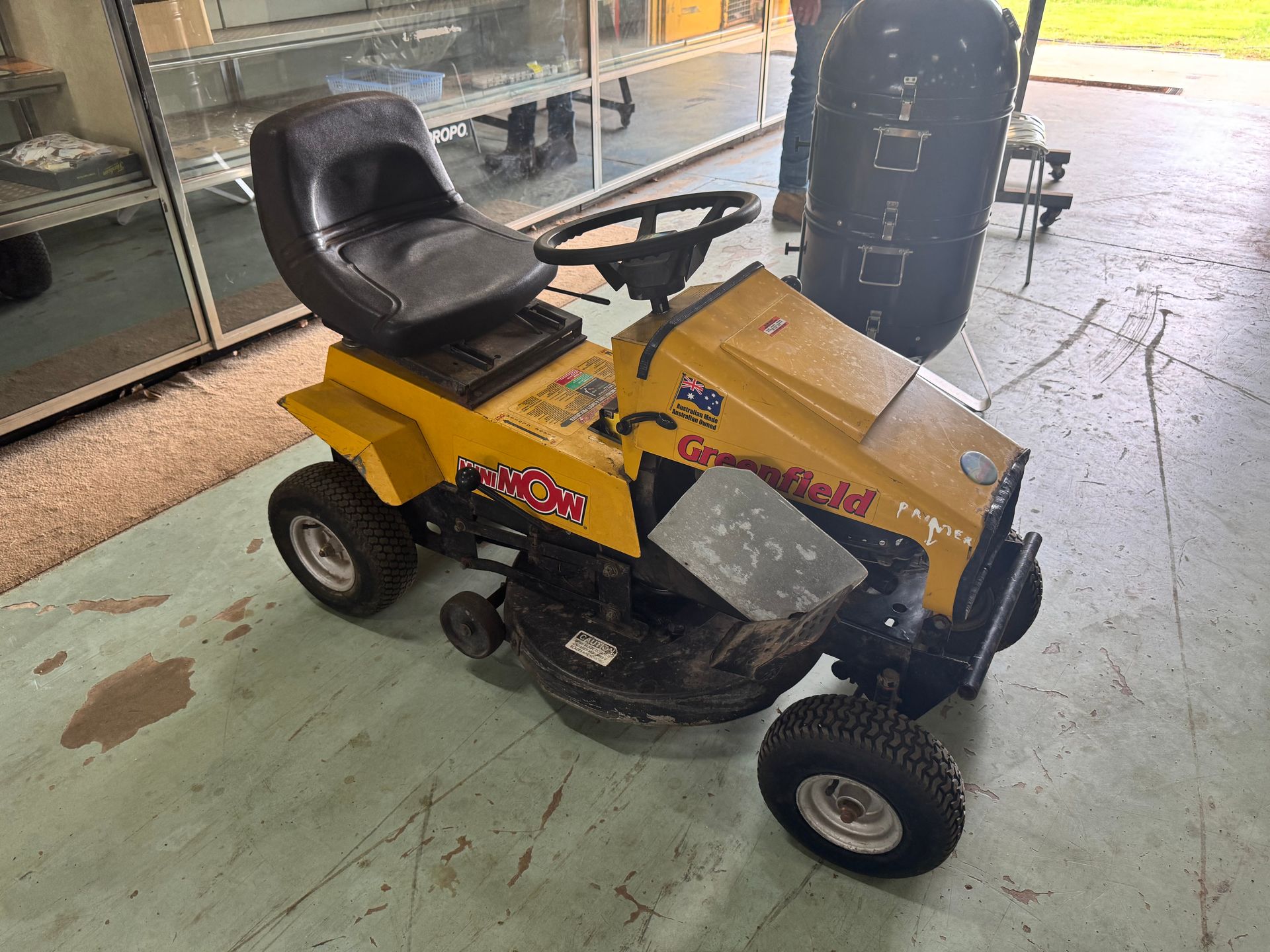 Yellow and Black Greenfield Ride-On Lawnmower on A Concrete Surface — Bundaberg Auction Centre in Gooburrum, QLD