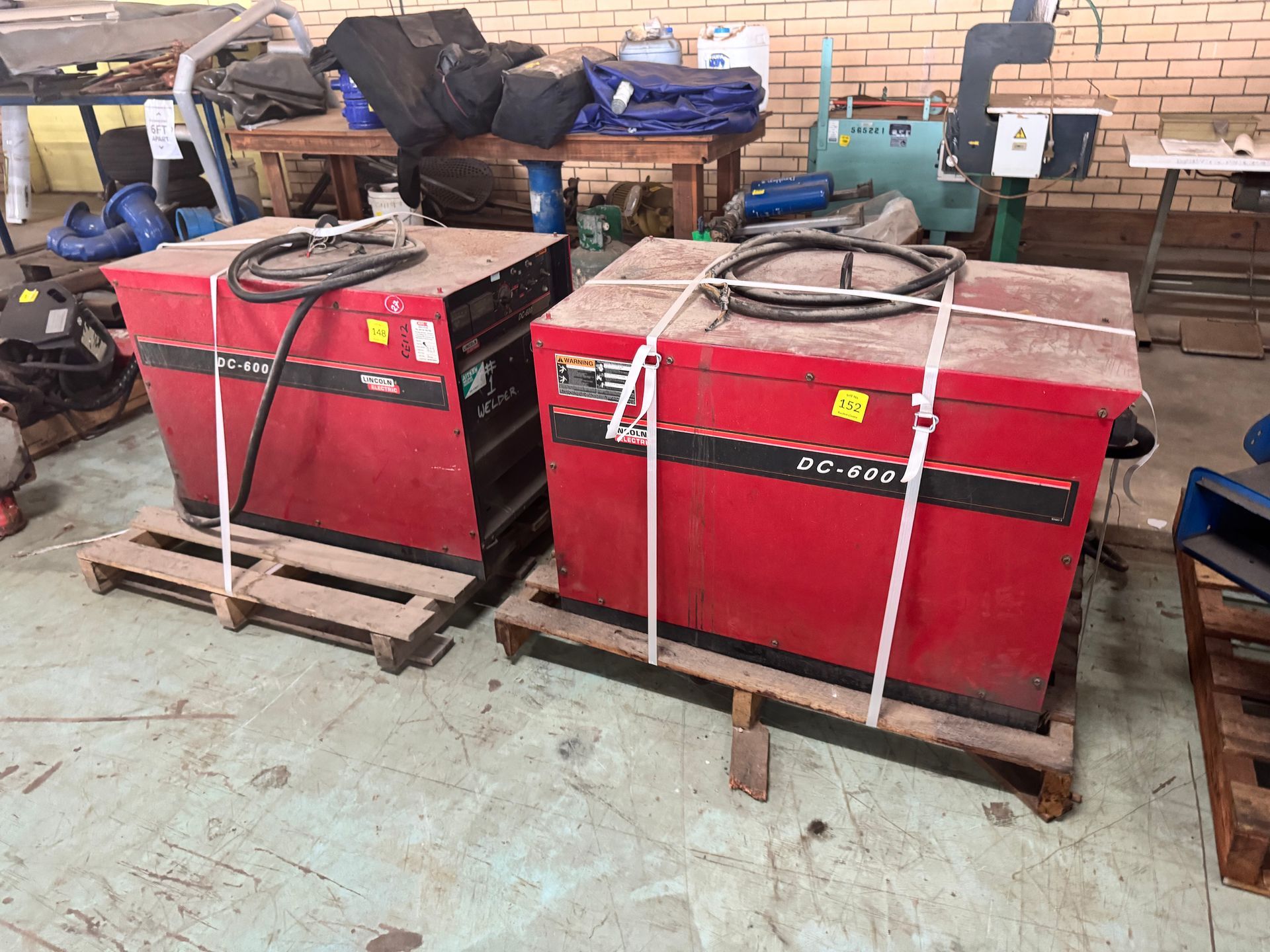 Two Red Industrial Machines, Strapped on Wooden Pallets, Sit in A Warehouse — Bundaberg Auction Centre in Gooburrum, QLD
