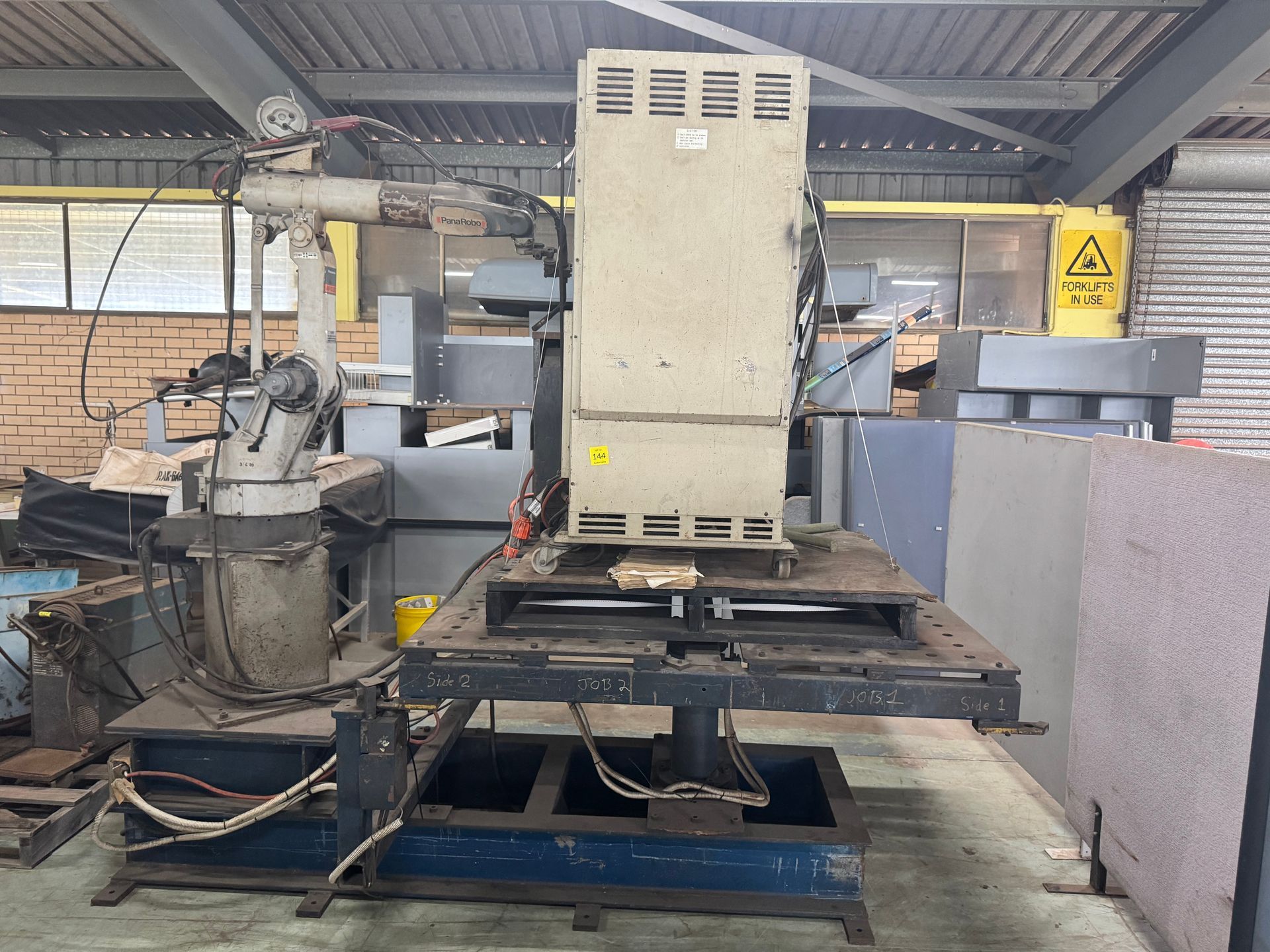 Industrial Robot Arm Next to A Large, Tan Electrical Cabinet on A Platform in A Workshop — Bundaberg Auction Centre in Gooburrum, QLD