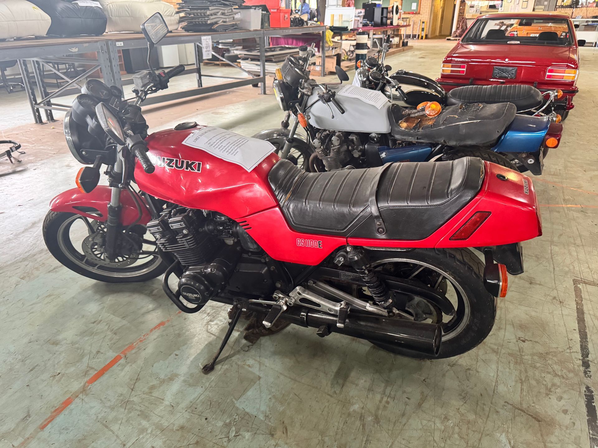 Red Yamaha Motorcycle Parked Indoors, Other Motorcycles and A Red Car Visible in Background — Bundaberg Auction Centre in Gooburrum, QLD