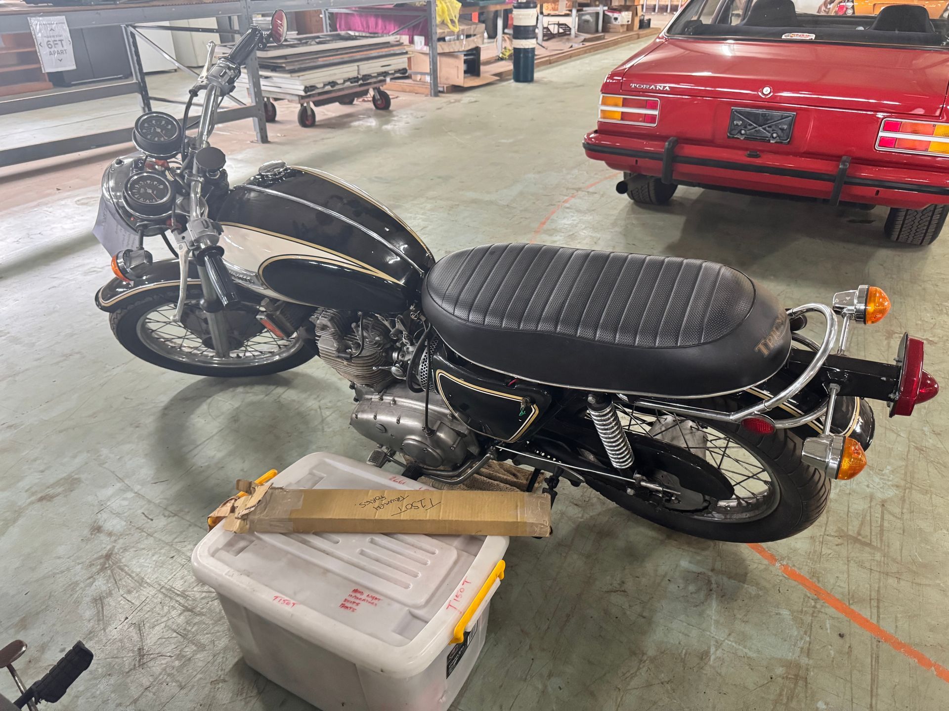 Black Motorcycle Parked in An Industrial Setting, with A Red Convertible in The Background — Bundaberg Auction Centre in Gooburrum, QLD