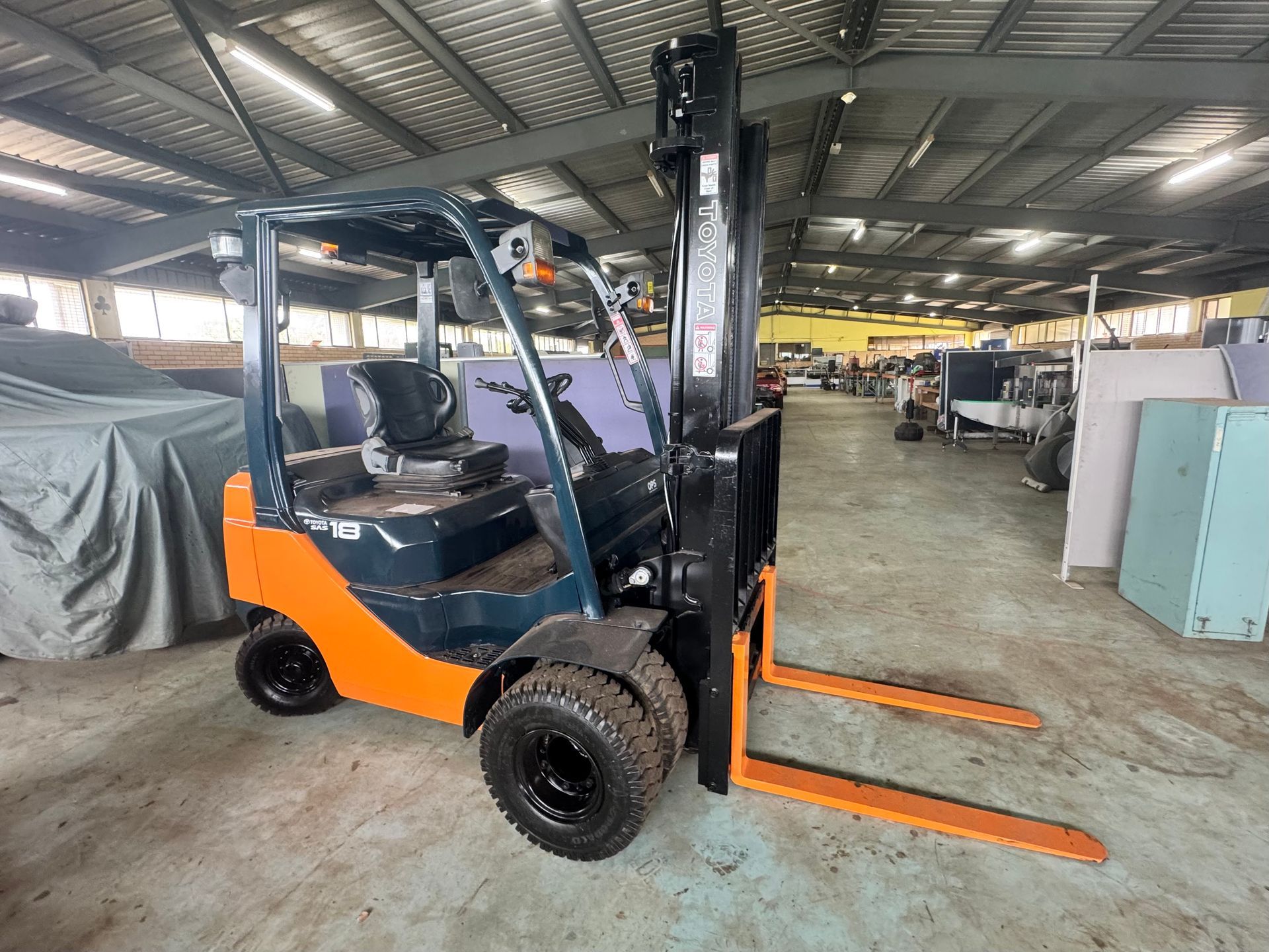 Orange and Blue Forklift Inside a Warehouse, Positioned on A Concrete Floor — Bundaberg Auction Centre in Gooburrum, QLD