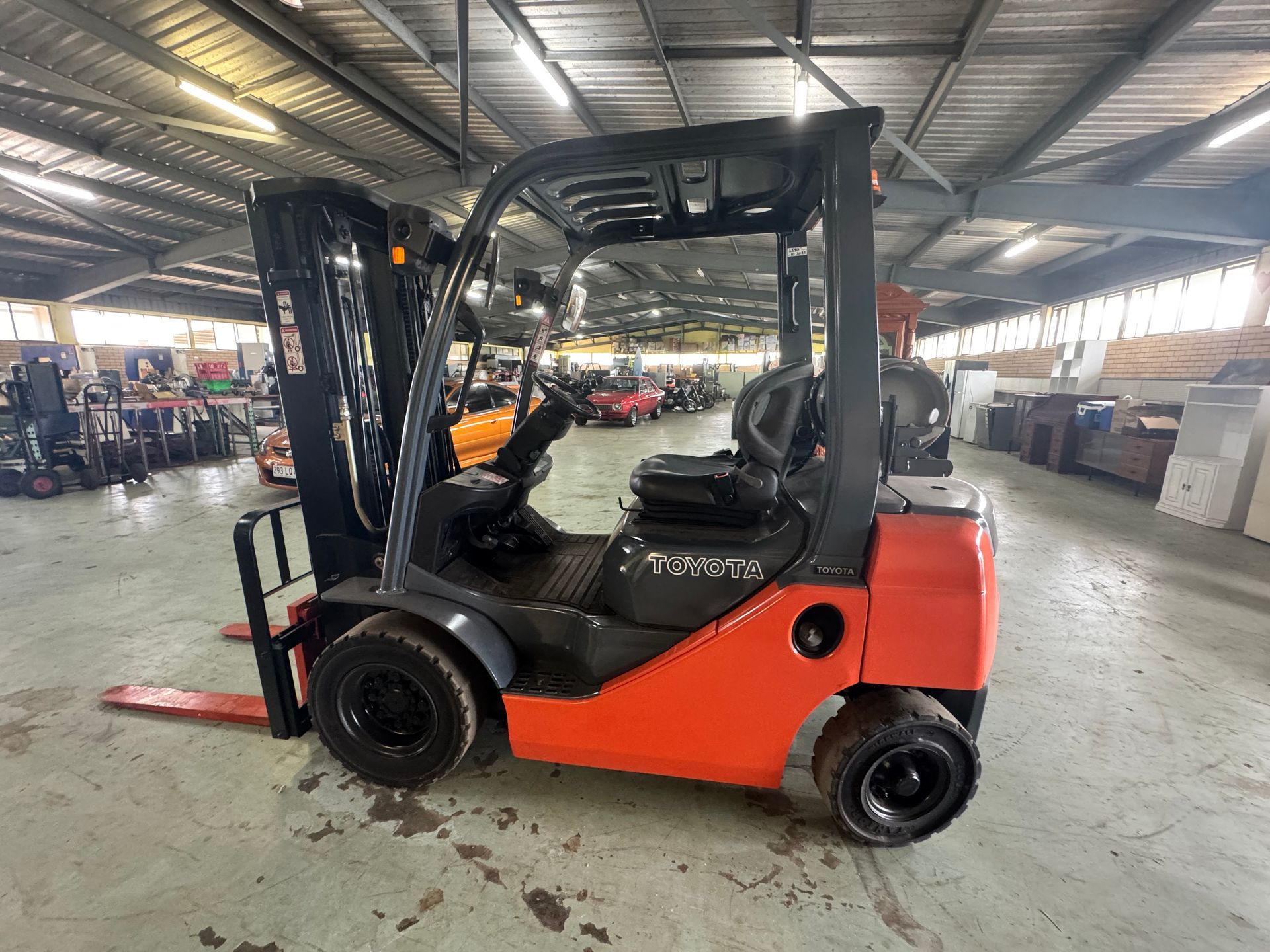 Red and Black Forklift Inside a Warehouse, with Visible Forks and Overhead Guard — Bundaberg Auction Centre in Gooburrum, QLD