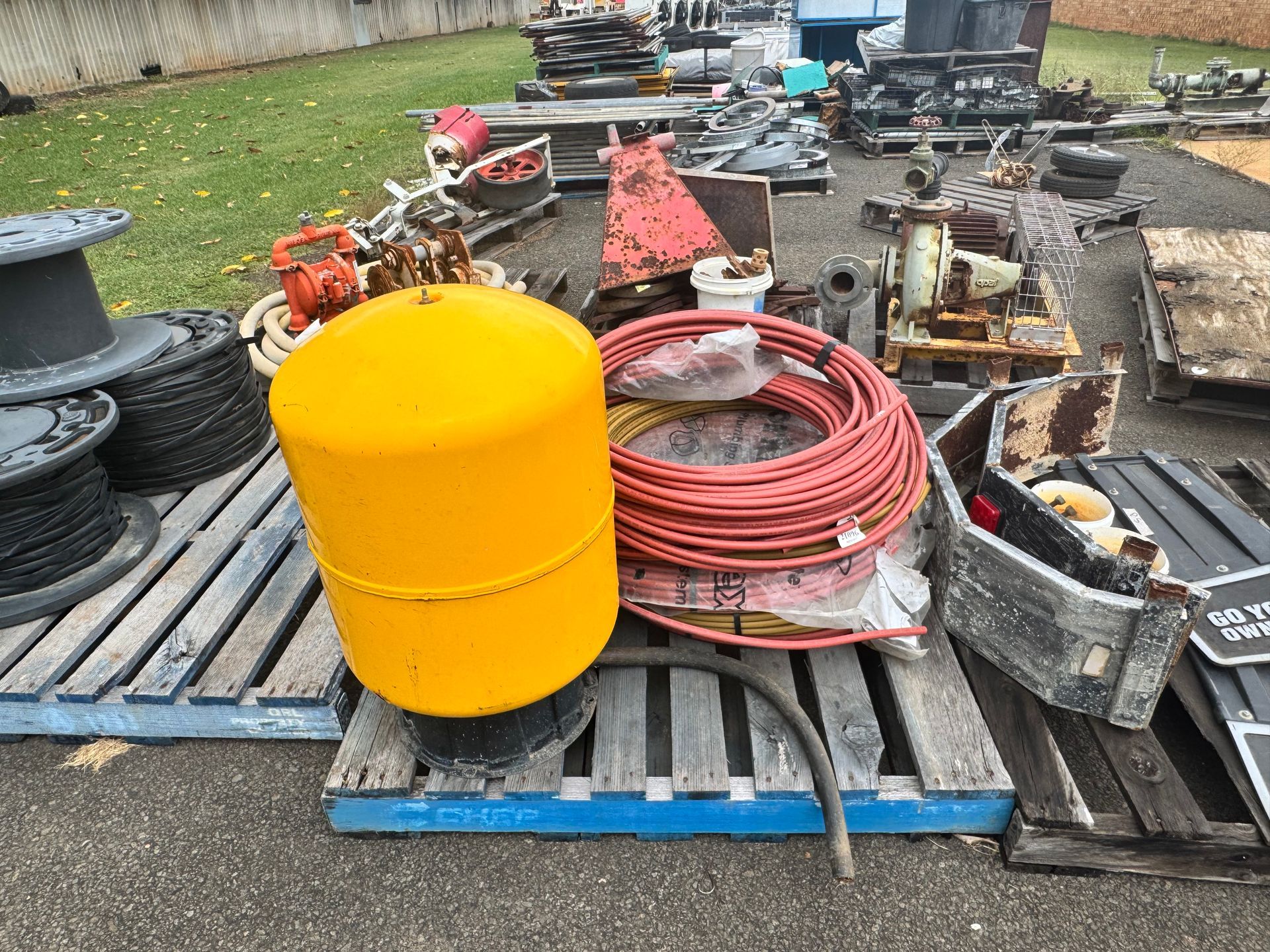 Yellow Buoy, Red Hose Coil, and Various Equipment on Pallets — Bundaberg Auction Centre in Gooburrum, QLD