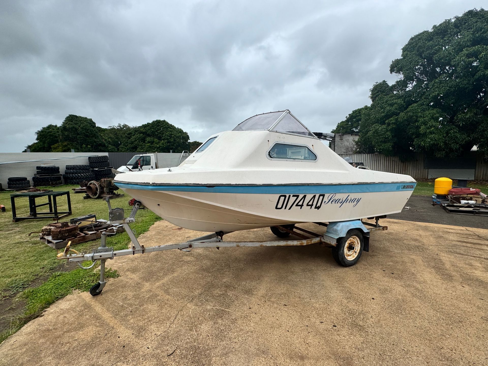 White Boat on Trailer Parked on Gravel — Bundaberg Auction Centre in Gooburrum, QLD