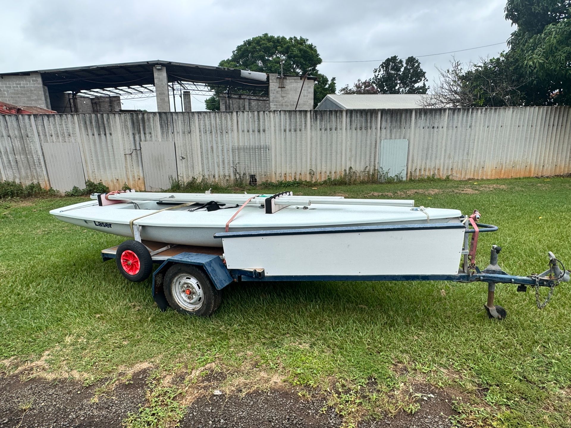 A Small White Sailboat on A Trailer, Parked on Grass — Bundaberg Auction Centre in Gooburrum, QLD
