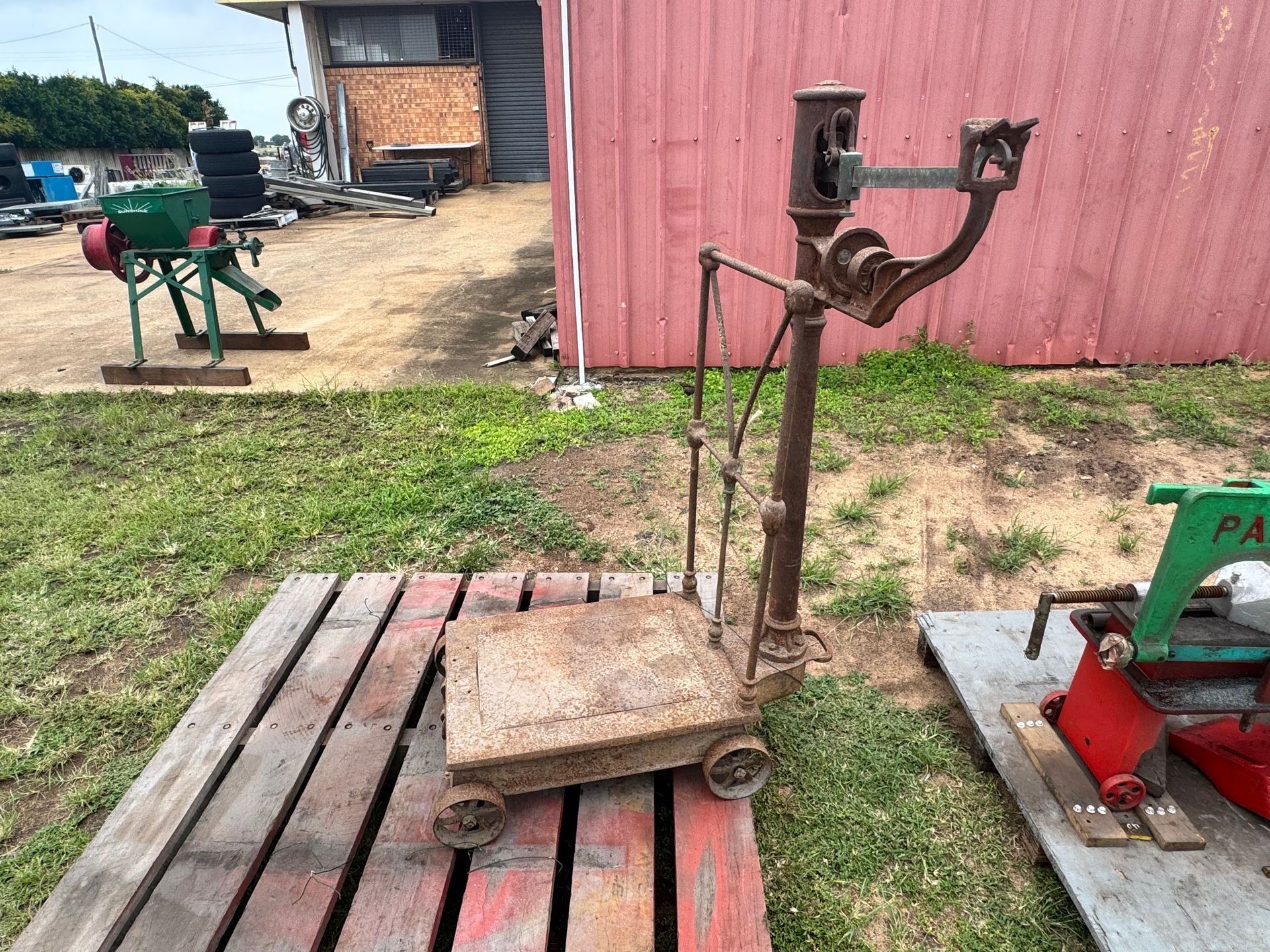 Antique Rusty Standing Scale on A Wooden Pallet Outdoors — Bundaberg Auction Centre in Gooburrum, QLD