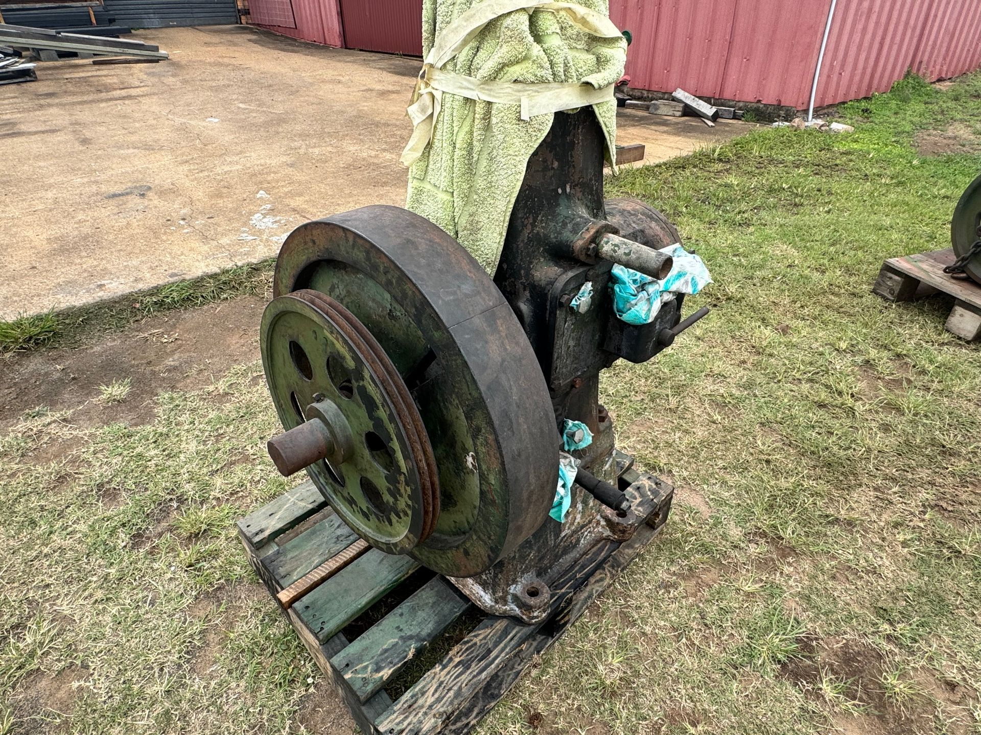 An Old, Green Industrial Engine on A Wooden Pallet, with A Flywheel and Pulley — Bundaberg Auction Centre in Gooburrum, QLD