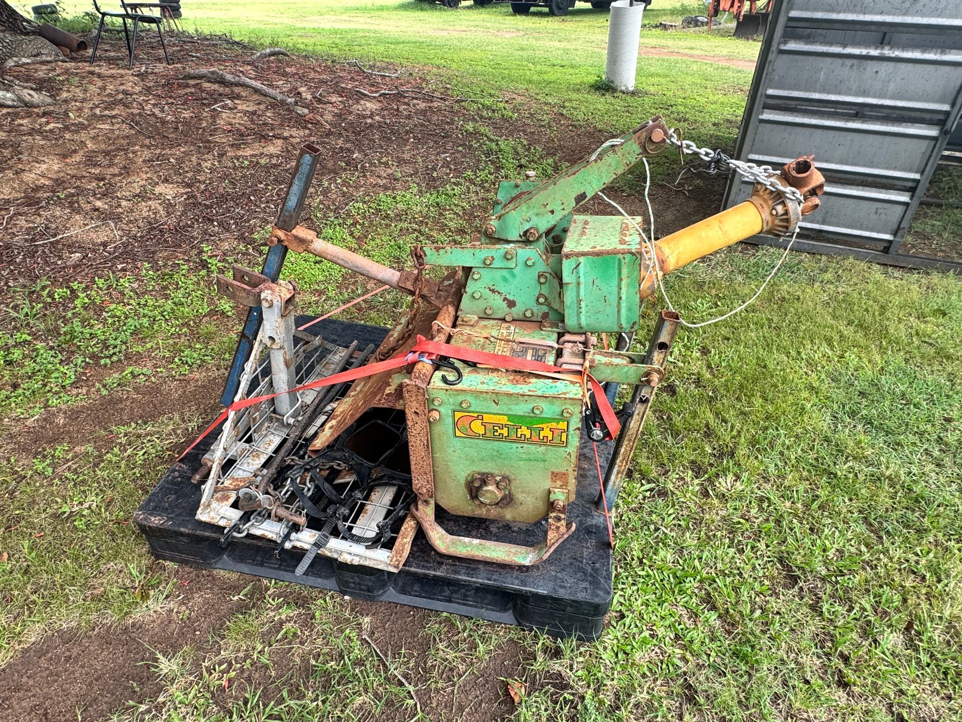 A Weathered, Green Construction Compactor Machine on A Black Pallet, Outdoors on Grass — Bundaberg Auction Centre in Gooburrum, QLD