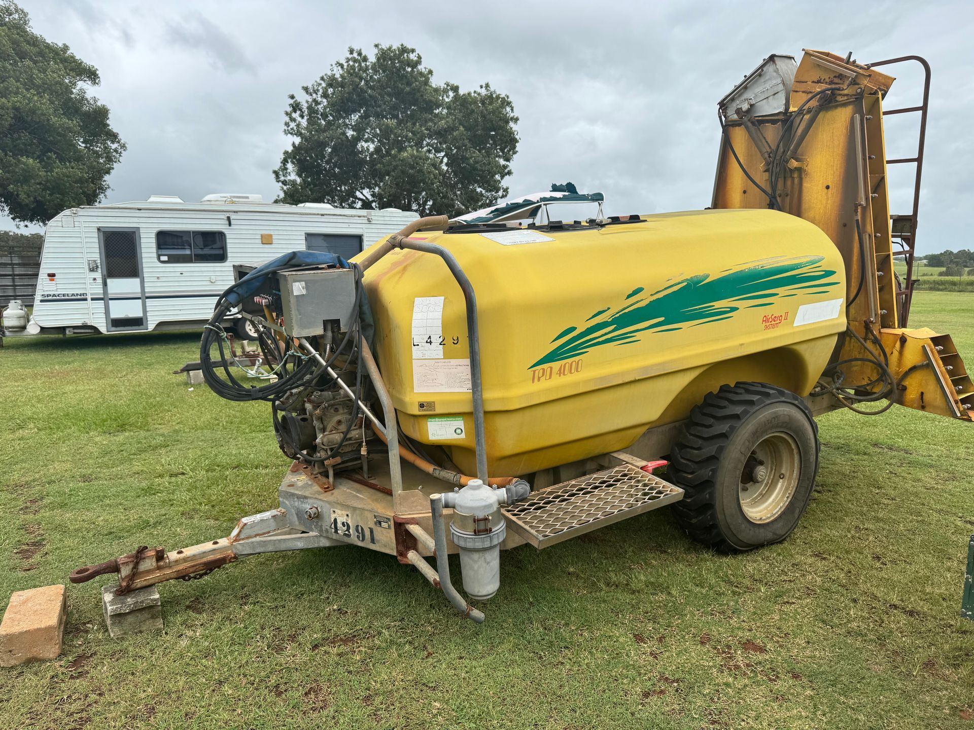 Yellow Agricultural Sprayer on Wheels, Trailer Hitch, Field Setting, White Camper in Background — Bundaberg Auction Centre in Gooburrum, QLD