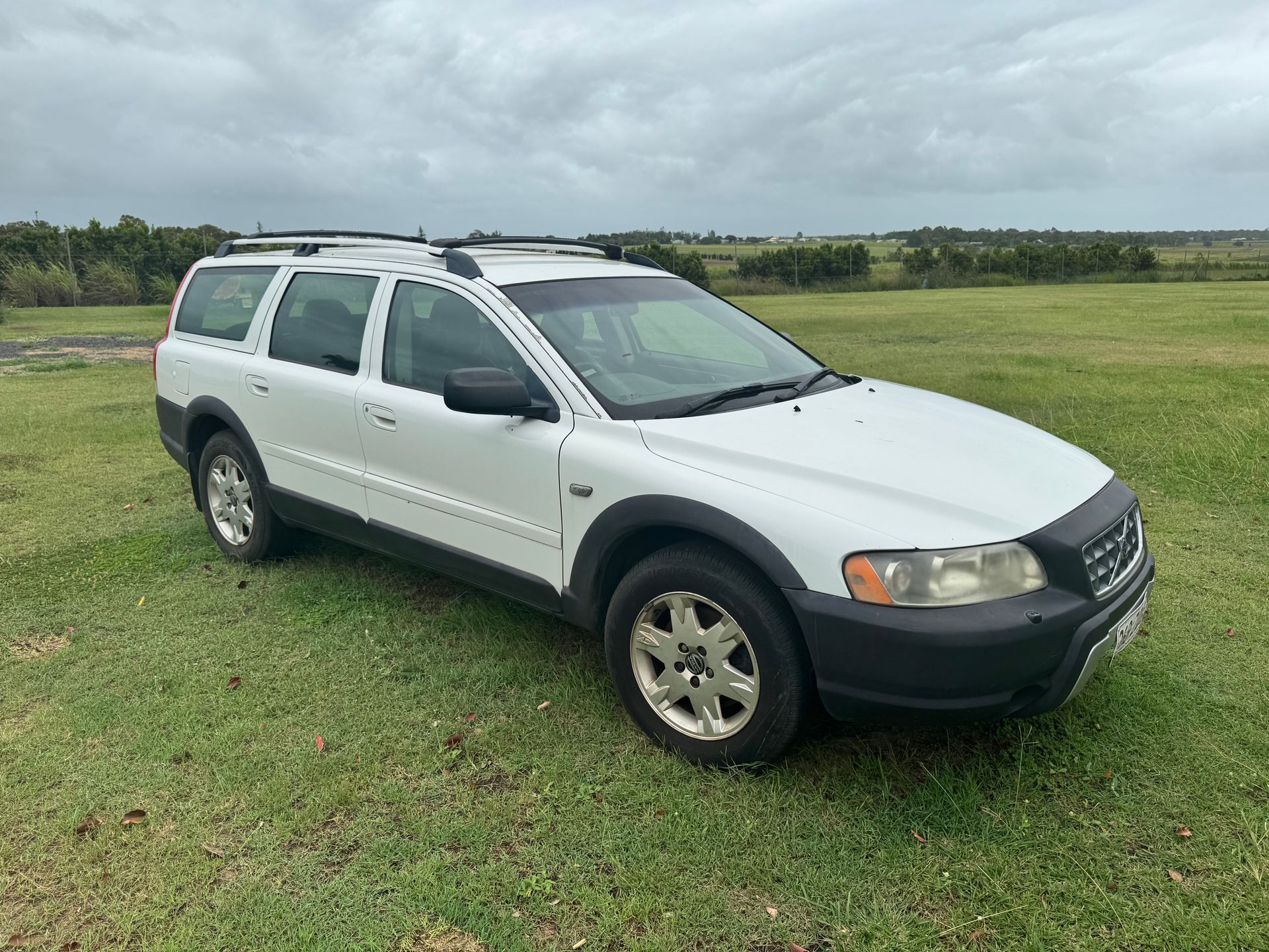 White Volvo Xc70 Wagon on Grassy Field Under Overcast Sky — Bundaberg Auction Centre in Gooburrum, QLD