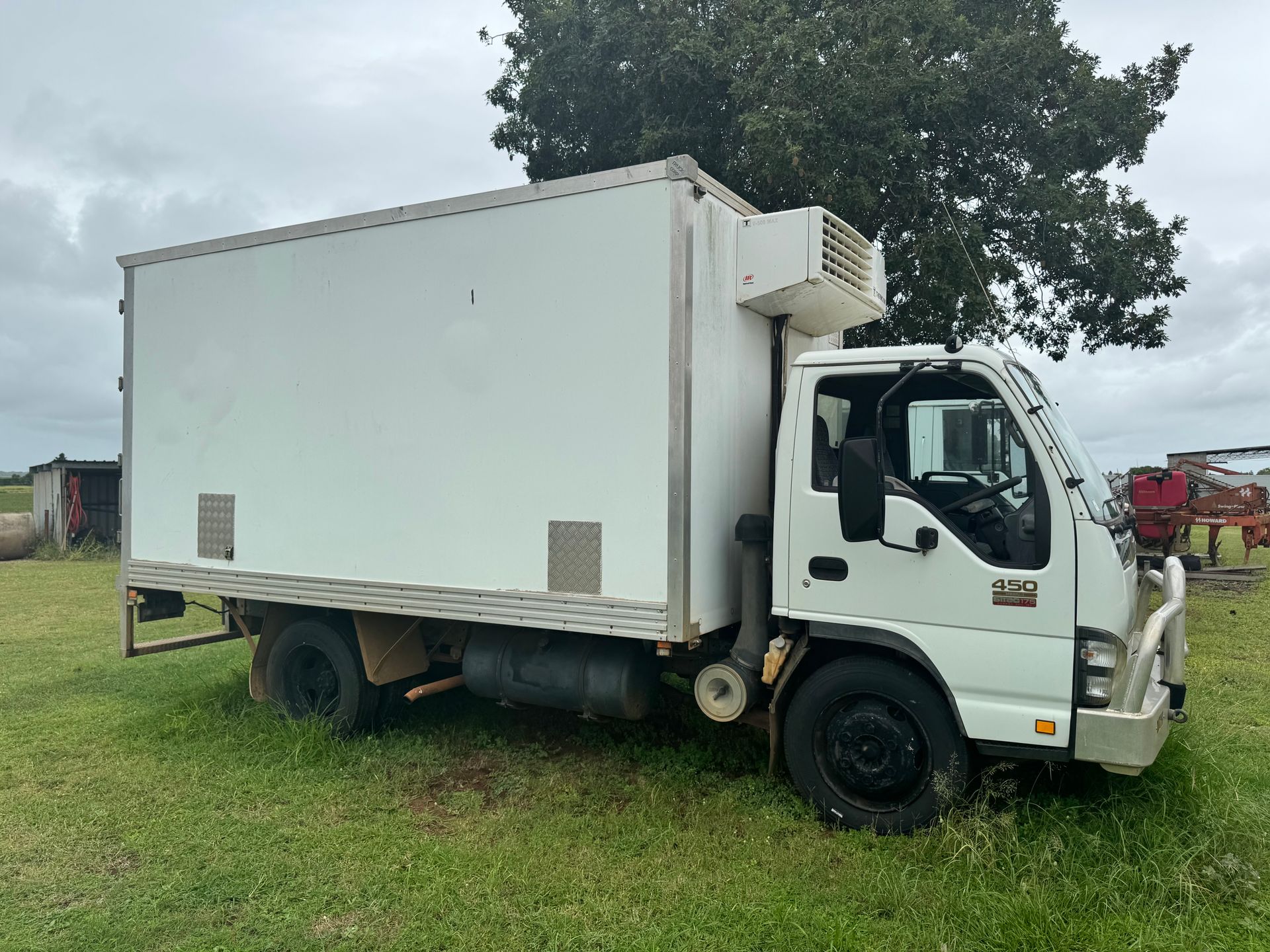 White Refrigerated Truck Parked in A Grassy Field — Bundaberg Auction Centre in Gooburrum, QLD