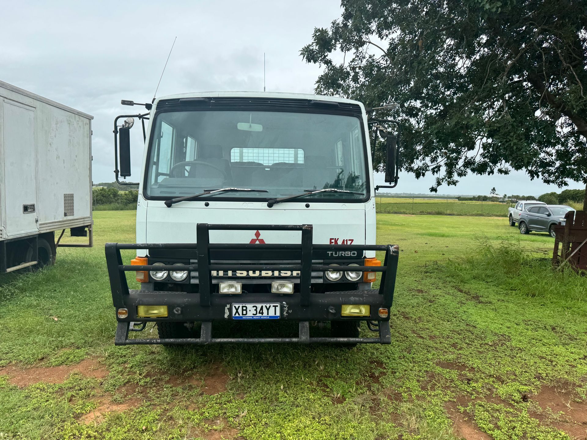 White Mitsubishi Truck with Black Bull Bar Parked on A Grassy Field  — Bundaberg Auction Centre in Gooburrum, QLD