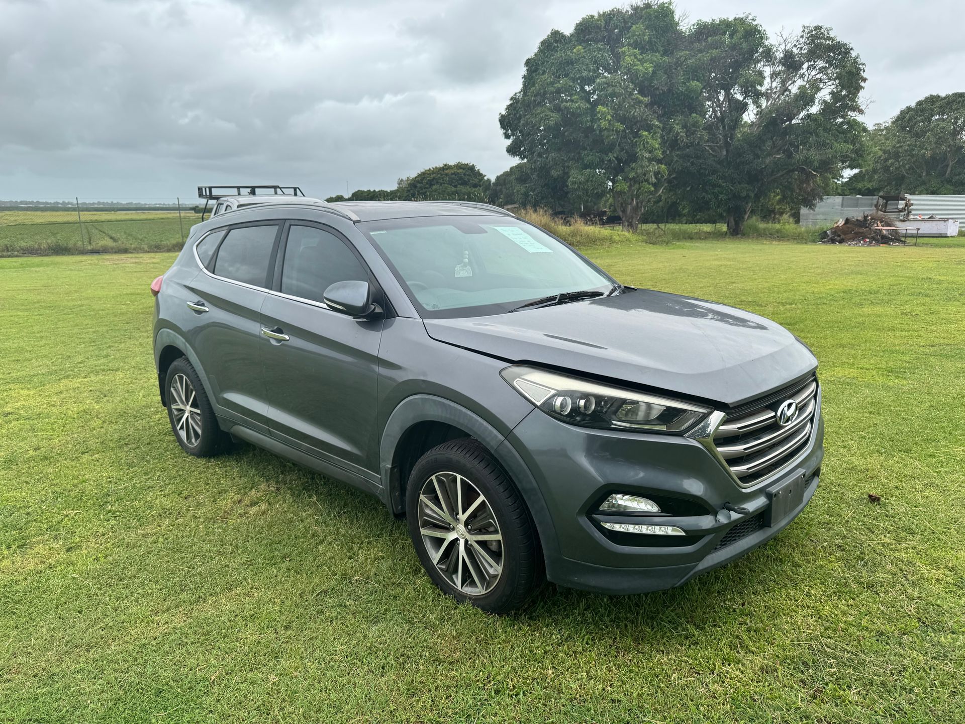 Gray Hyundai Tucson Suv Parked on Grassy Field, Overcast Sky — Bundaberg Auction Centre in Gooburrum, QLD