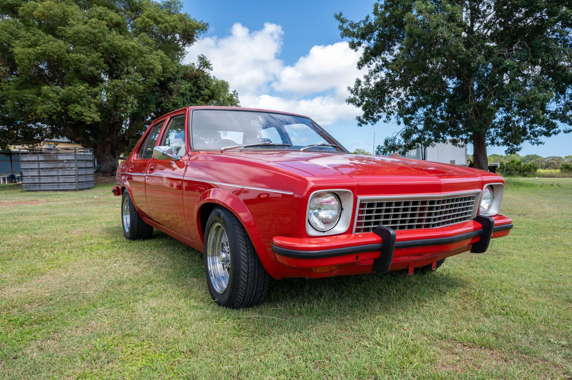 Red Classic Car Parked on Grass, Front View — Bundaberg Auction Centre in Gooburrum, QLD
