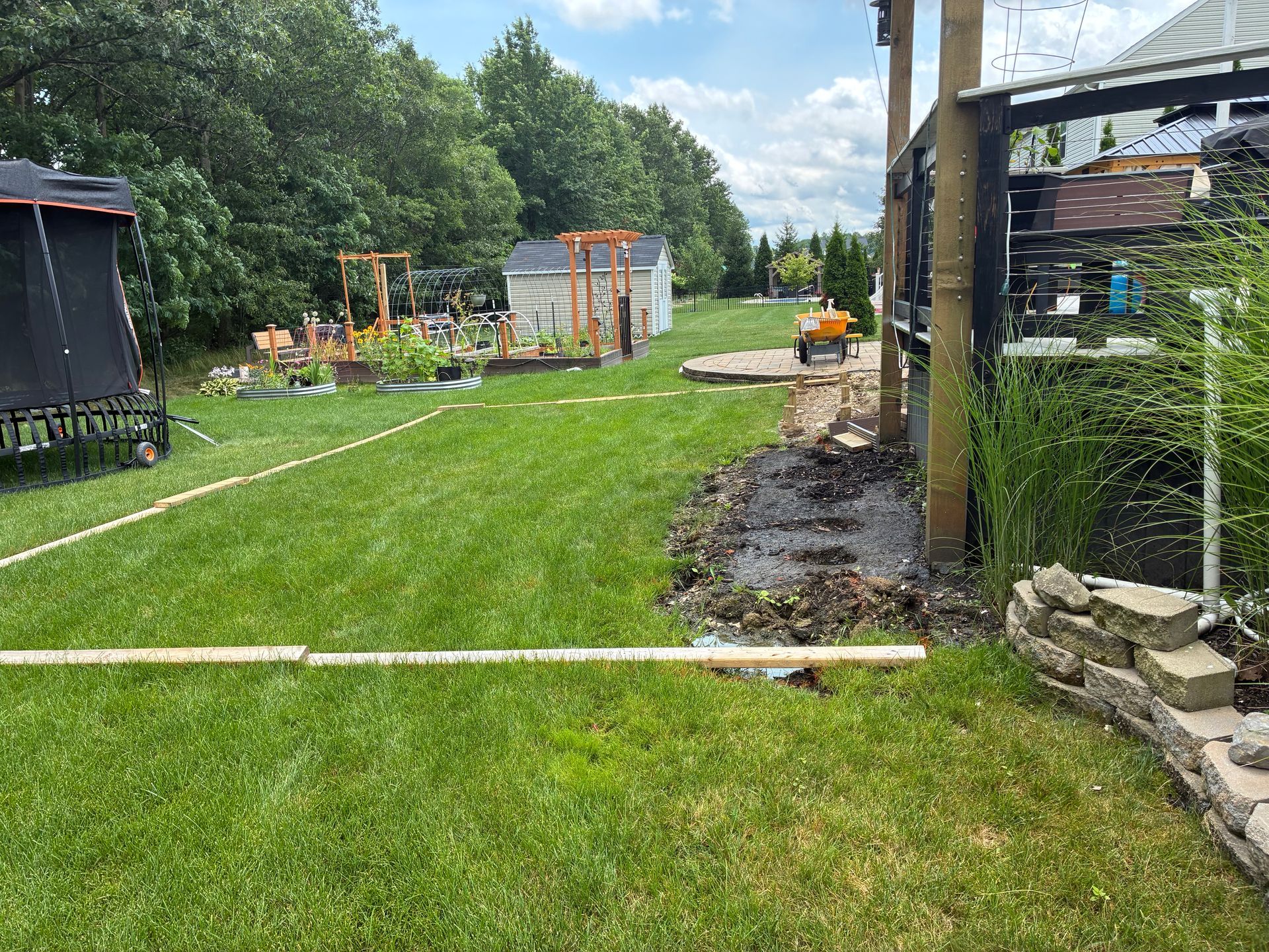 Backyard with lawn, garden, shed, and construction debris.