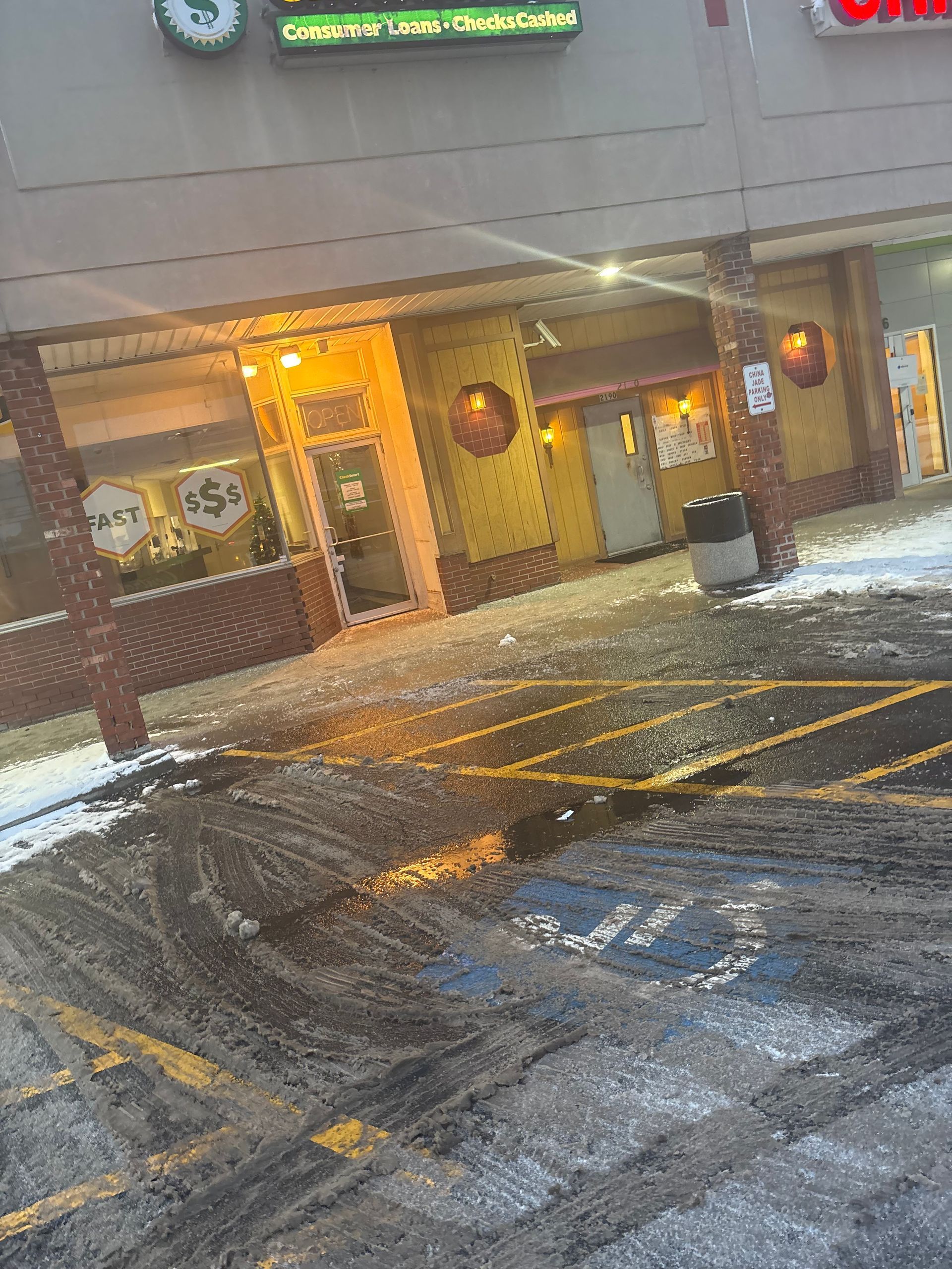 Exterior of a restaurant building, yellow and brick, with snow on the ground in front.