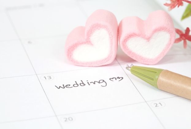 calendar with pen, text reads Wedding Day with heart candies on it