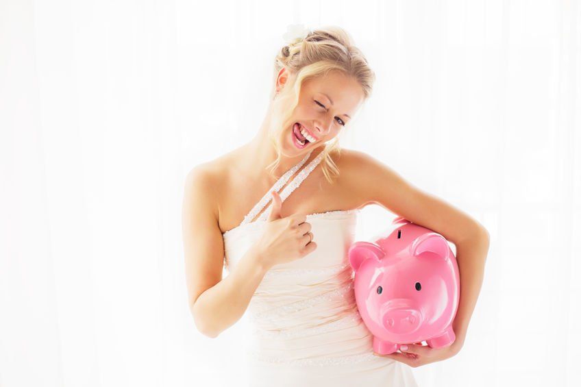 bride holding piggy bank to save money on her wedding