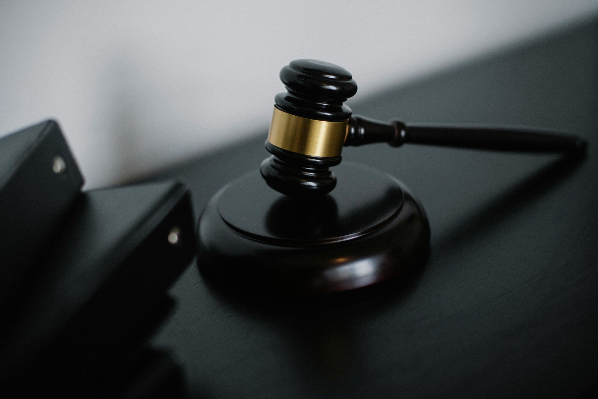 A judge 's gavel is sitting on top of a black table.