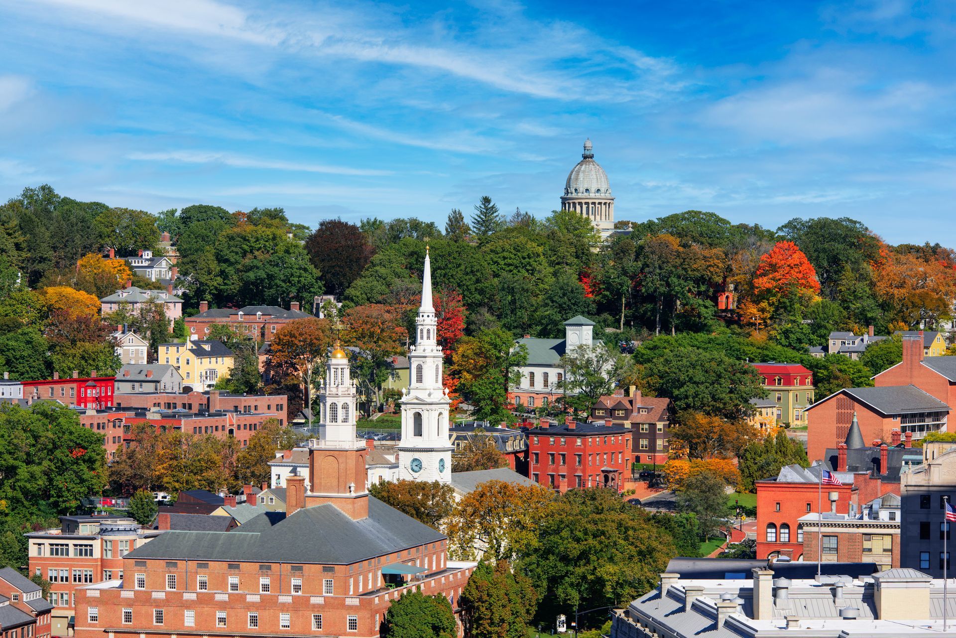 An aerial view of a city with a church and a dome in the background.