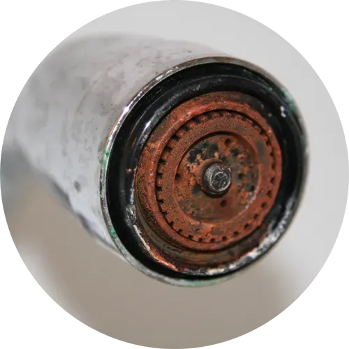 Close-up of a rusted faucet aerator, showing mineral buildup and corrosion.