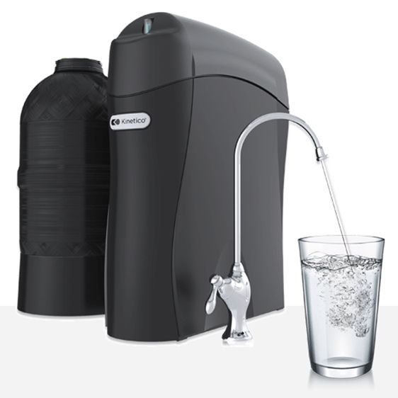 Black water filtration system with a spout pouring water into a glass.